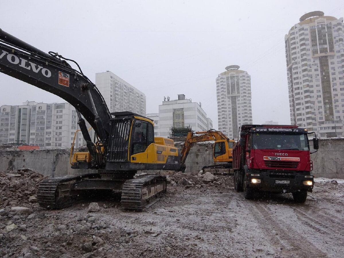 Экскаватор и самосвал на стройке